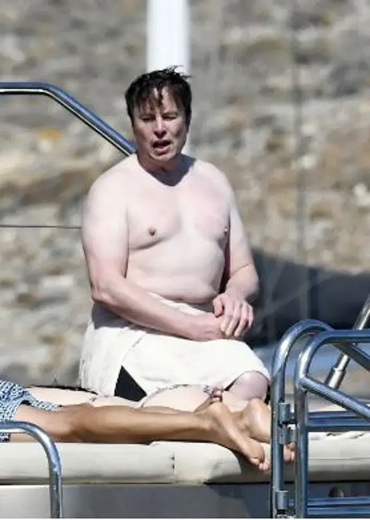 elon musk on a boat looking like an overweight vampire